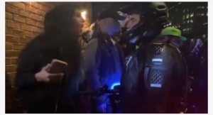 Protestuesja Anti-TRUMP pështyn në fytyrë oficerin e policisë, arrestohet me force