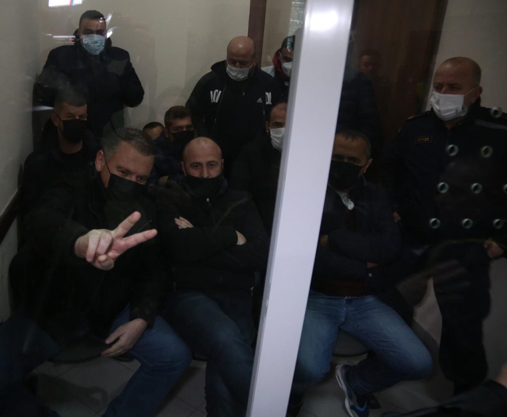 FOTO/ Të arrestuarit pas 8 janarit brenda selisë së PD në gjykatë për masën e sigurisë, shfaqen me dy gishta dhe të qetë