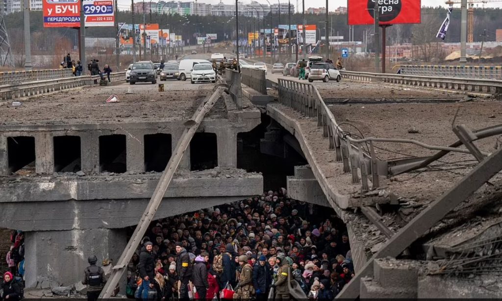 Qytetarët ukrainas duke u fshehur nën urën e shkatërruar përpiqen t’i shpëtojnë bombardimeve ruse