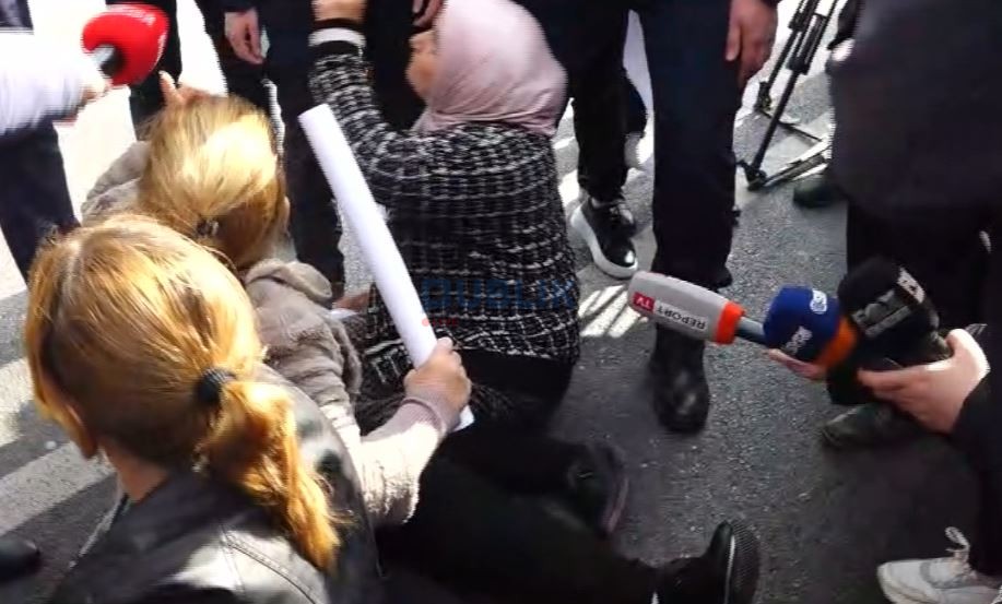 Protestuesit e Bërxullës/ “Mos më prek!”, të moshuarat bllokojnë rrugën e shtrihen në asfalt: Të na ngrejë shteti, jo policia!